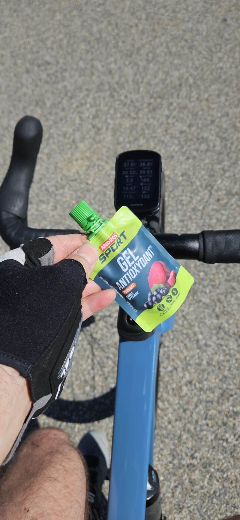 photo prise lors d'une sortie vélo de route avec un gel andros sport dans la main