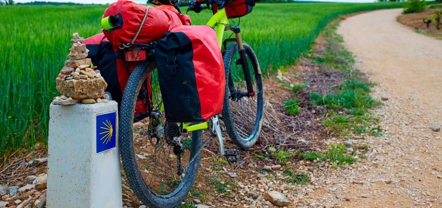 photo d'un velo garé devant la borne kilometrique du parcours de saint jacques de compostelle